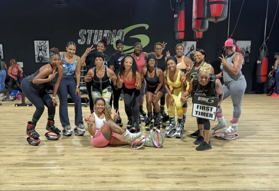 Smiling class members in rebound boots holding an I Survived The Takeoff sign